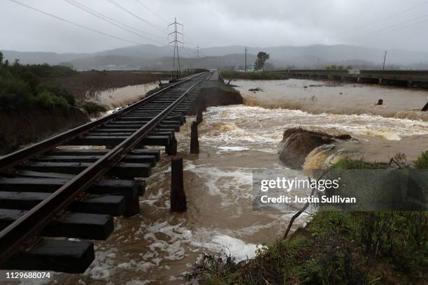 Water flows under railroad tracks after a levee breach during a rain storm on February 14, 2019 in Novato, California. 50 homes in the town of...