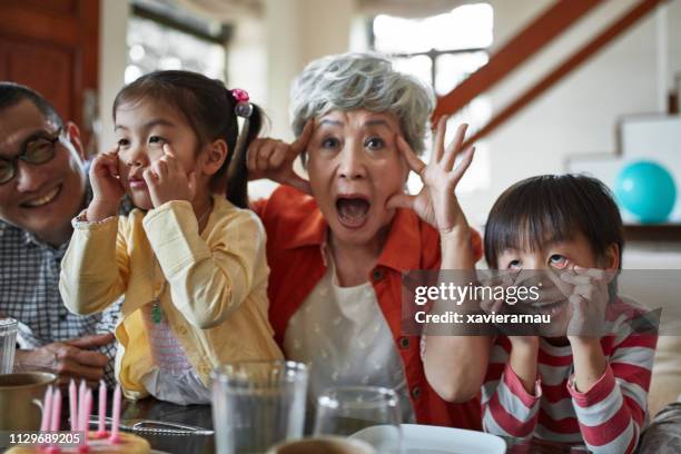 grandparents and children making faces at home - hong kong grandmother stock pictures, royalty-free photos & images