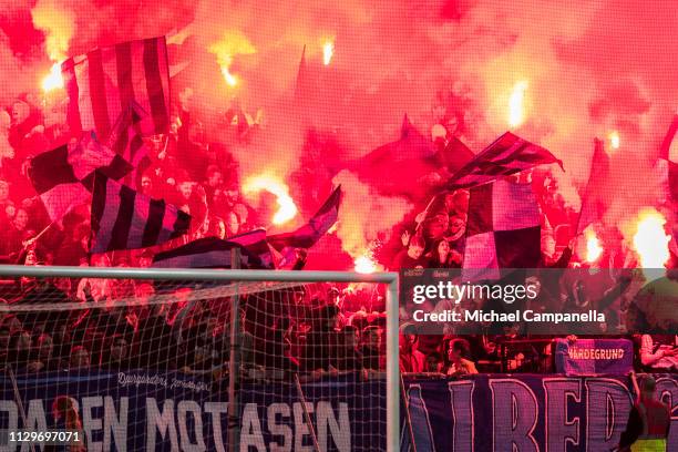 Djurgarden supporters wave light flares during a quarter-final match in the Swedish Cup between Djurgardens IF and Hammarby IF at Tele2 Arena on...