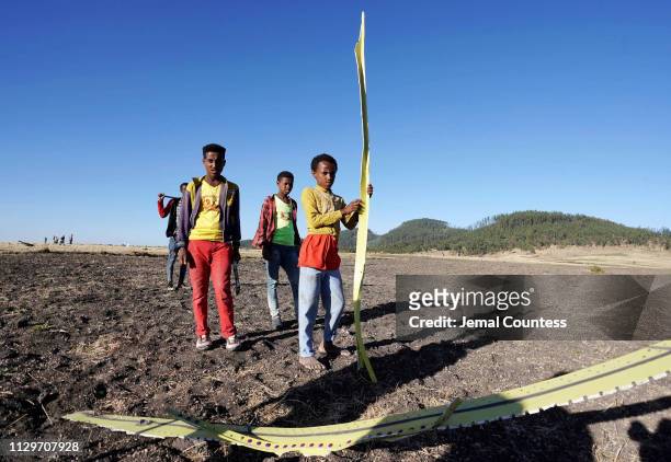 Local residents collect debris at the scene where Ethiopian Airlines Flight 302 crashed in a wheat field just outside the town of Bishoftu, 62...
