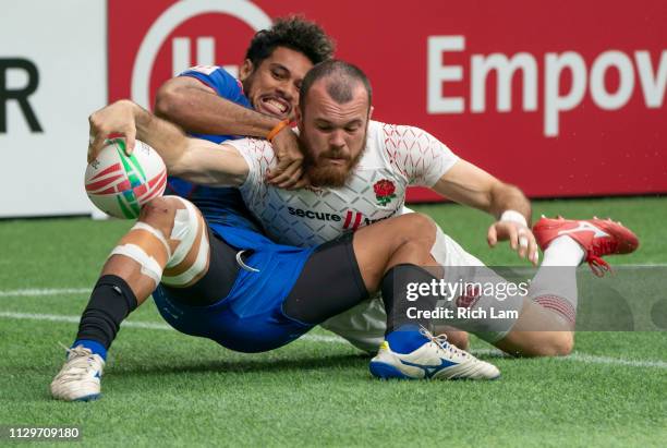 Tom Bowen of England reaches for the try line while being tackled by Elisapeta Alofipo of Samoa during rugby sevens action on Day 2 of the HSBC...