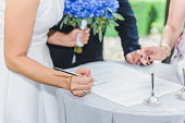 Wedding day. Bride signs on marriage certificate