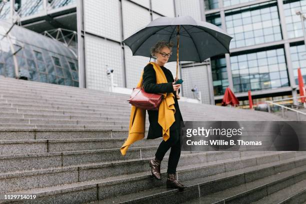businesswoman walking in the rain - walk to work woman bildbanksfoton och bilder