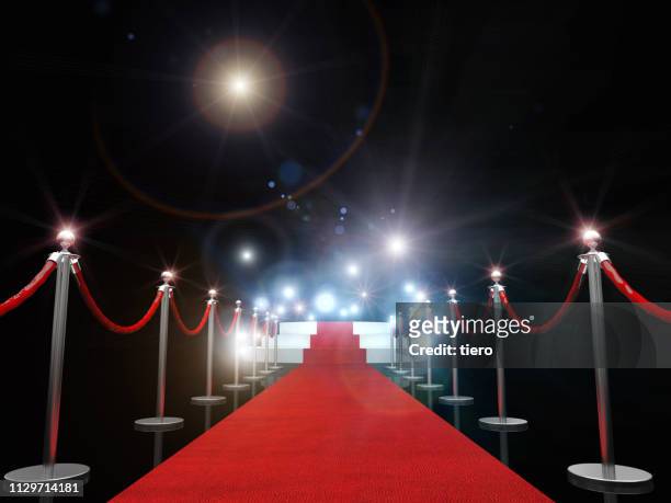 red carpet amidst bollards against illuminated lights - red carpet foto e immagini stock