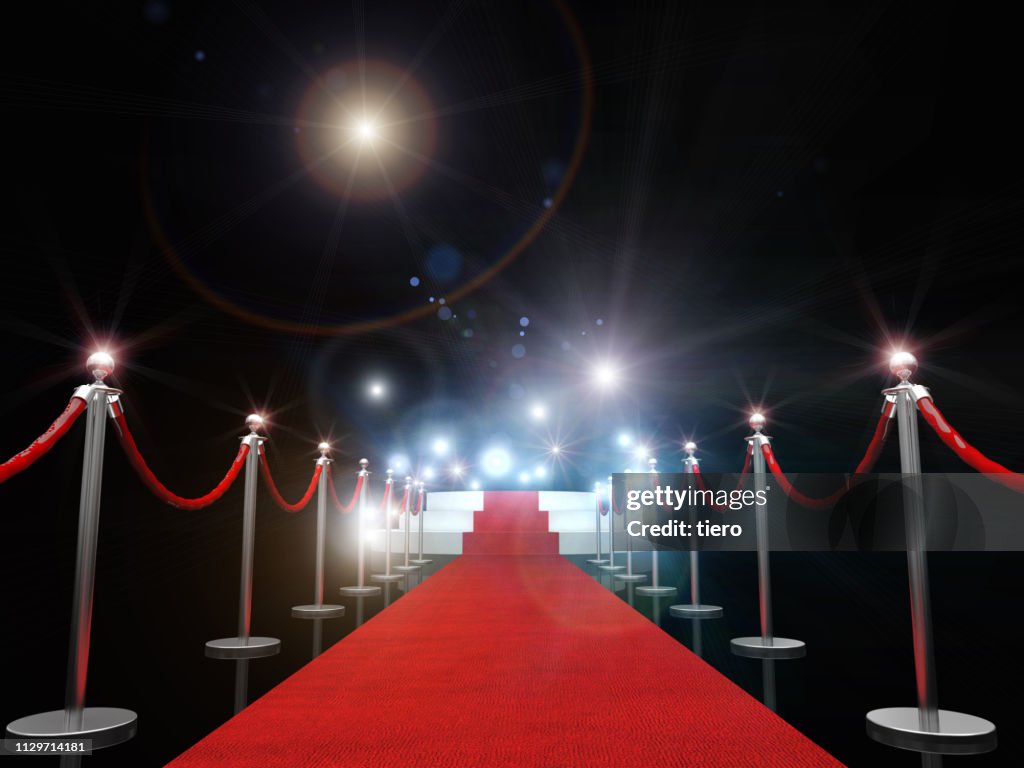 Red Carpet Amidst Bollards Against Illuminated Lights