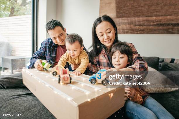 cosy family evening with kids and parents - chinese canadian family stock pictures, royalty-free photos & images
