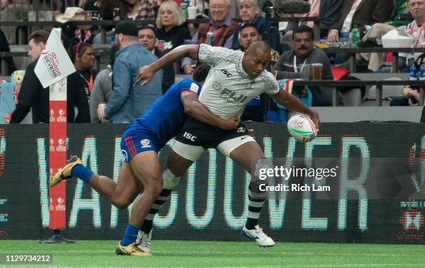 Paula Dranisinukula of Fiji tries to break free from the tackle of Marcus Tupuola of the United States during rugby sevens action on Day 2 of the...