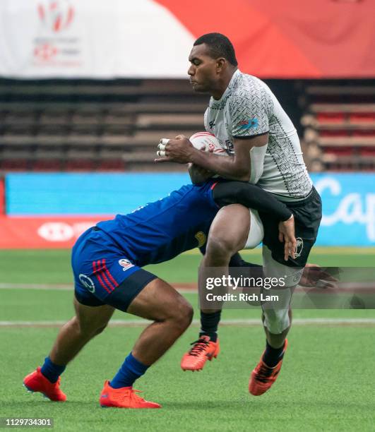 Mesulame Kunavula of Fiji tries to break free from the tackle of Maceo Brown of the United States during the bronze medal game on Day 2 of the HSBC...