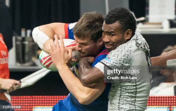 Jerry Tuwai of Fiji wraps up Brett Thompson of the United States during the bronze medal game on Day 2 of the HSBC Canada Sevens at BC Place on March...