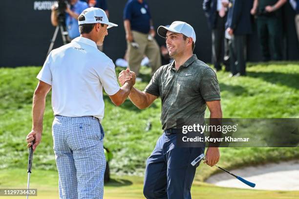 Francesco Molinari of Italy is congratulated by Billy Horschel after making a birdie putt on the 18th hole green during the final round of the Arnold...