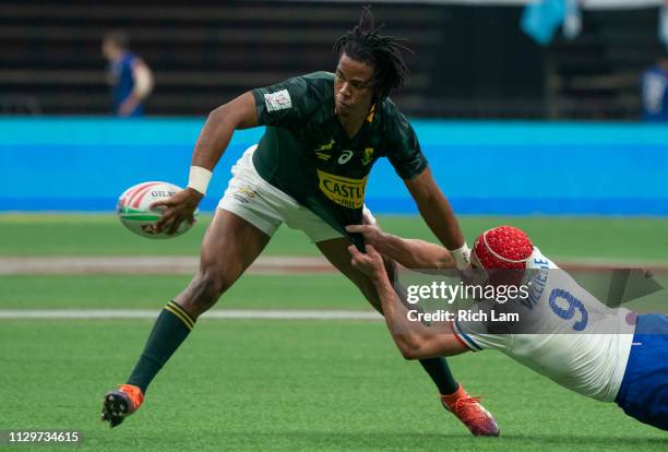 Stedman Gans of South Africa passes the ball off after getting tackled by Gabin Villiere of France during the championship final on Day 2 of the HSBC...