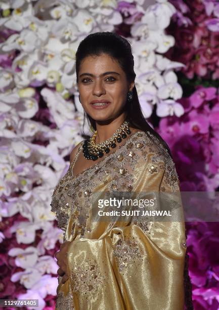 Indian Bollywood actress Kajol Devgn poses for photographs as she arrives to attend the wedding reception of Akash Ambani, son of Indian businessman...