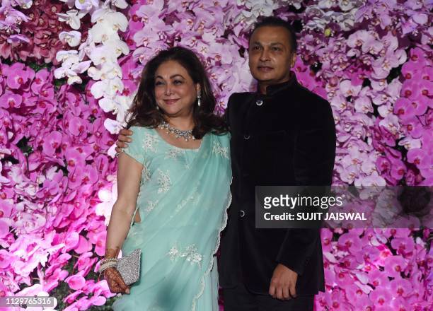 Indian businessman Anil Ambani poses for photographs along with his wife and former Bollywood actress Tina Ambani as they arrive to attend the...