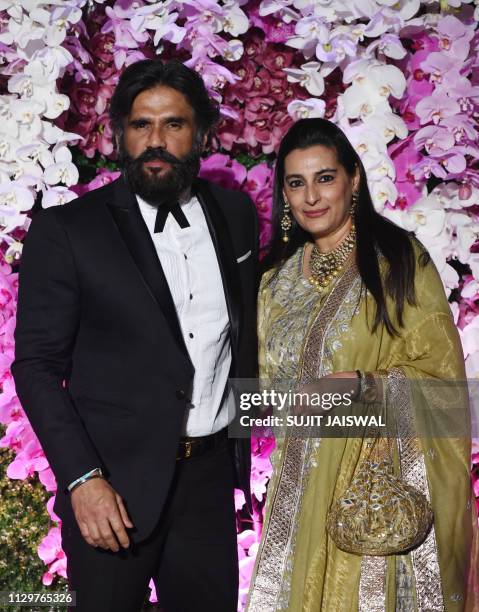 Indian Bollywood actor Suniel Shetty with his wife Mana Shetty arrives to attend the wedding reception of Akash Ambani, son of Indian businessman...