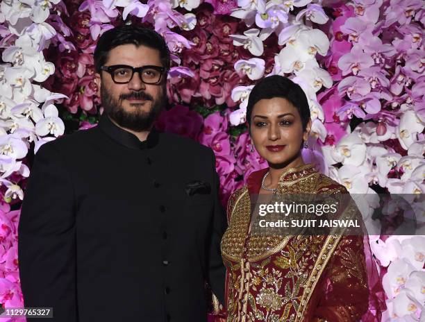 Indian Bollywood actress Sonali Bendre with her husband film director Goldie Behl poses for photographs as she arrives to attend the wedding...