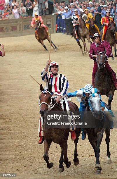 The winner of the "Palio di Siena," from the Istrice district, raises his hand in victory July 2, 2002 at the Piazza del Campo, in Siena, Italy. The...