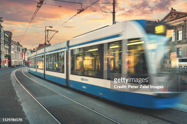 tram in amsterdam, the netherlands - straßenbahnstrecke stock-fotos und bilder