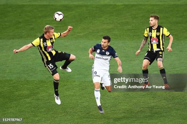 Michał Kopczynski of the Phoenix competes for the ball against Kosta Barbarouses of the Victory during the A-League match between the Wellington...