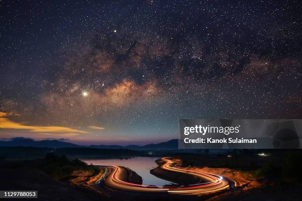 milky way over curve road - long exposure sky stock pictures, royalty-free photos & images