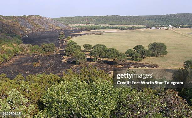 Charred lands show how a fire almost reached the farm house on the Kimberlin Brazos Ranch in Palo Pinto County, Texas, Friday, April 22, 2011.