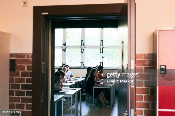 students learning language in classroom seen through doorway - classroom door stock pictures, royalty-free photos & images