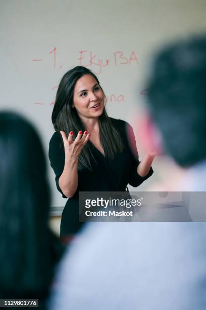 mid adult woman gesturing while teaching students in language school - student visa stockfoto's en -beelden