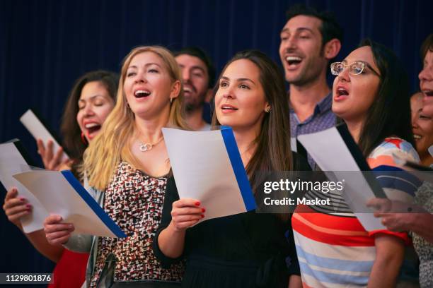 multi-ethnic friends singing at choir practice in language school - student on stage stock-fotos und bilder