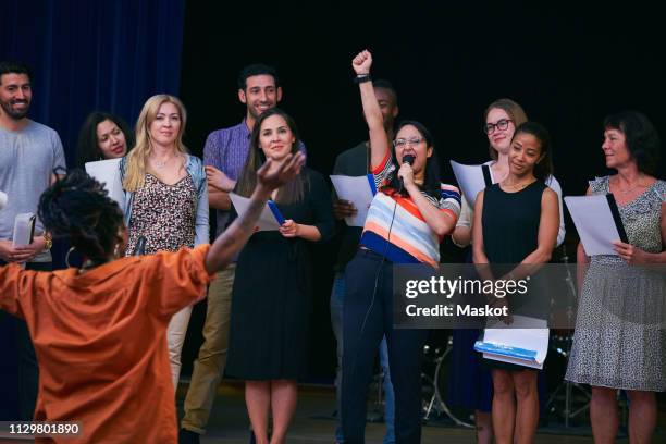 choir singer with friends performing on stage in auditorium - choir stage stockfoto's en -beelden