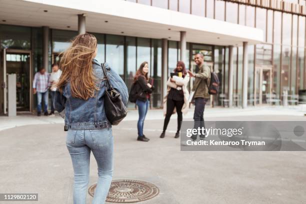 rear view of woman walking towards friends at university campus - hijab woman from behind stock pictures, royalty-free photos & images