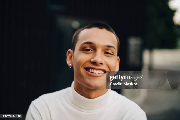 close-up portrait of smiling young man wearing turtleneck - 18 19 anni foto e immagini stock