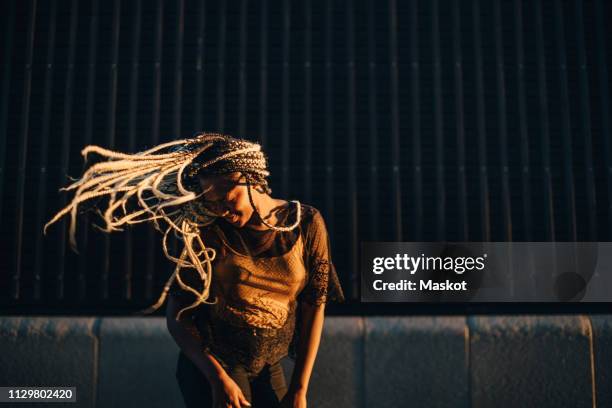 smiling teenage girl dancing with tousled long hair at skateboard park - hip hop dance fotografías e imágenes de stock