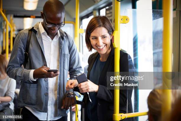 smiling multi-ethnic commuters standing in tram - tram stock pictures, royalty-free photos & images