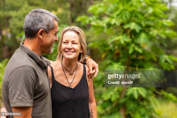 happy mature couple walking together by a river - rural australia stock pictures, royalty-free photos & images