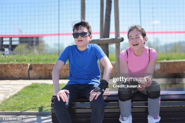 sibling taking a break on bench after exercising. - tween girls hot imagens e fotografias de stock