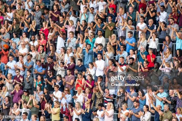 group of spectators cheering in stadium - crowd cheer stadium clapping stock pictures, royalty-free photos & images
