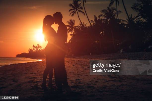 couple hugging at sunset - coconut beach woman stock pictures, royalty-free photos & images