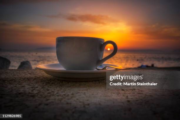 kaffeetasse und sonnenuntergang am meer - morgendämmerung stock pictures, royalty-free photos & images