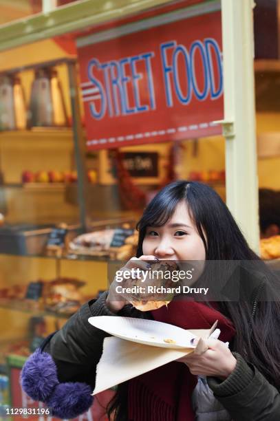 a young woman eating street food - adult eating no face stock pictures, royalty-free photos & images