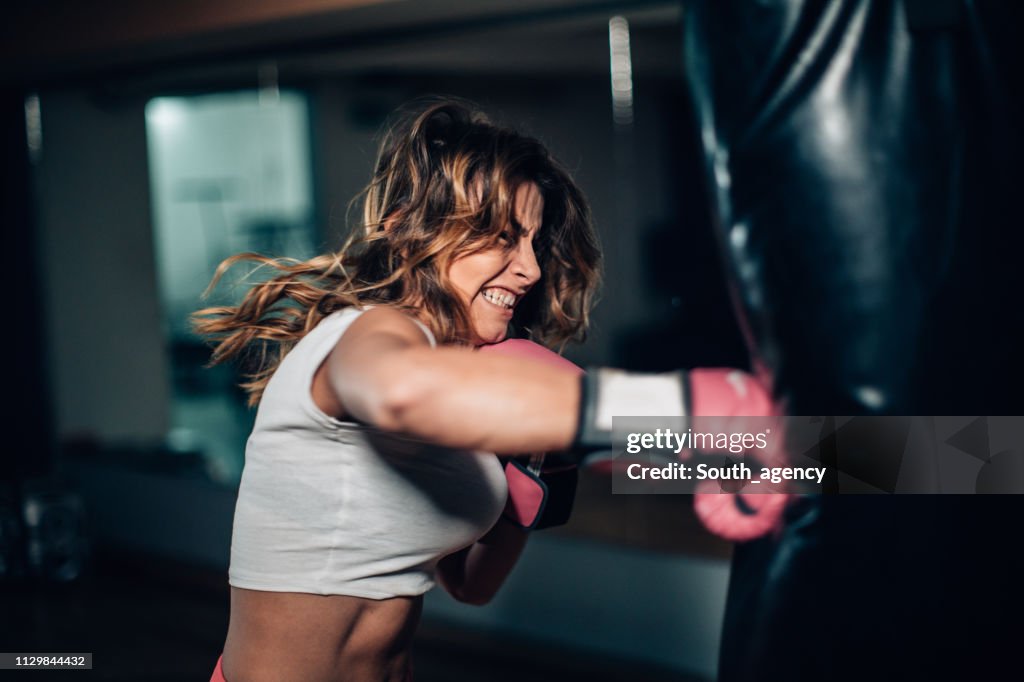 Woman boxer punching a punching bag