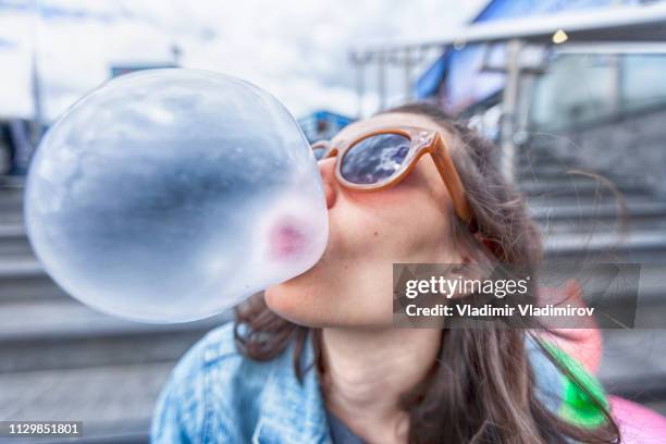 portret van de vrouw een zeepbel blazen kauwgom - silly girl stockfoto's en -beelden