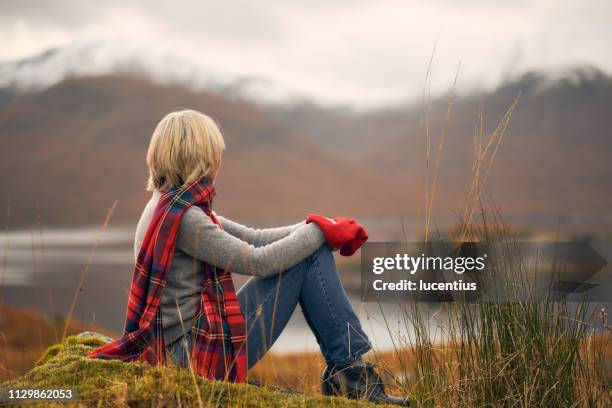 woman enjoying retirement in scotland highlands - plaid scarf stock pictures, royalty-free photos & images