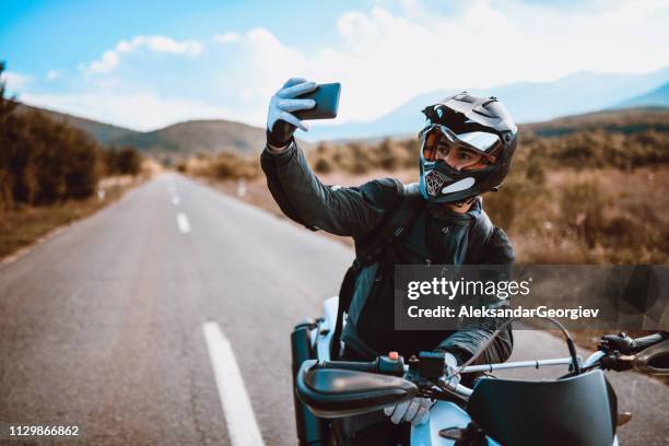 motorcyclist taking a selfie after a ride - motorcycle rider stock pictures, royalty-free photos & images