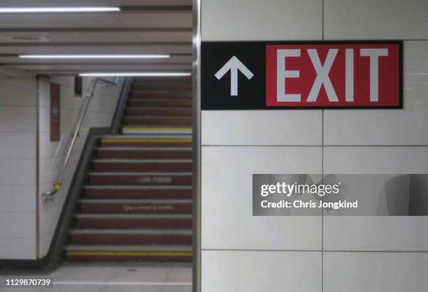 exit sign pointing to staircase - uitgang stockfoto's en -beelden