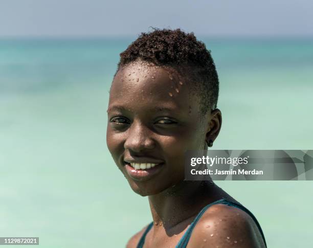 black skin girl in turquoise water - kids swimsuit models stockfoto's en -beelden