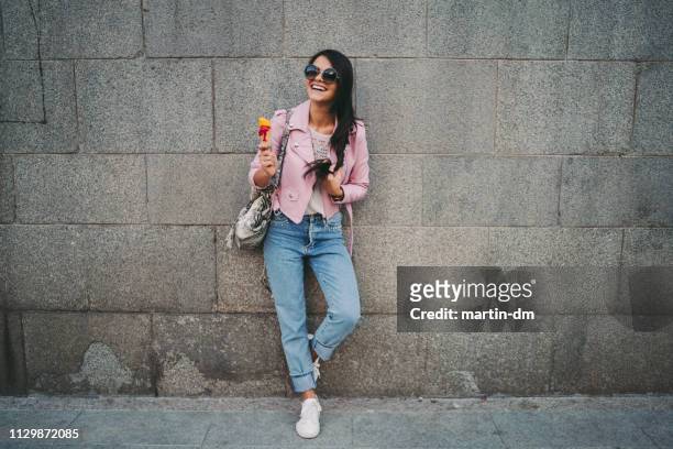 linda garota na cidade comendo sorvete - jeans calça comprida - fotografias e filmes do acervo