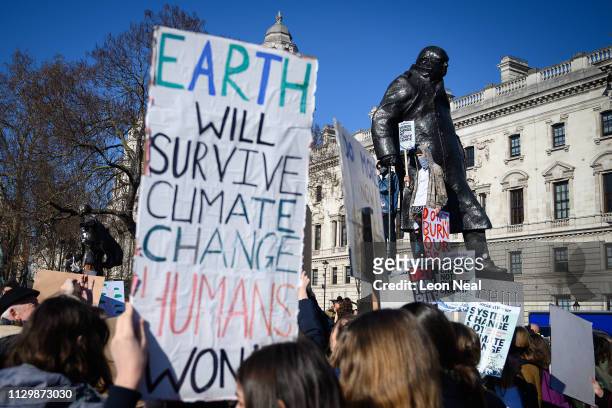 Students stand on the plinth of a statue of former Prime Minister Winston Churchill during a climate protest in Parliament Square on February 15,...