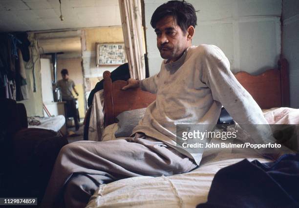 Man sits on a bed at his house, Pike County, Kentucky, US, 1967.