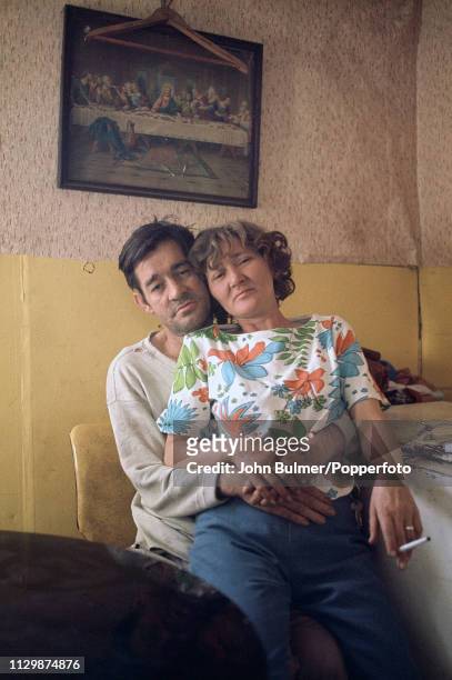 Man holding his wife who is sitting on his lap at their house in Pike County, Kentucky, US, 1967.