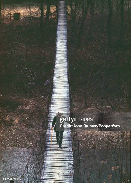 An elder man crossing a primitive rope bridge in Pike County, Kentucky, US, 1967.