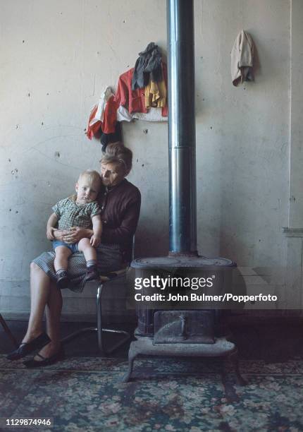 Woman and a child sitting near an old coal stove, Pike County, Kentucky, US, 1967.